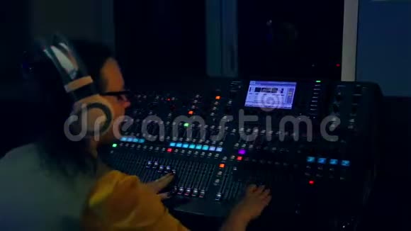 女DJ在彩色照明混合控制台工作视频的预览图