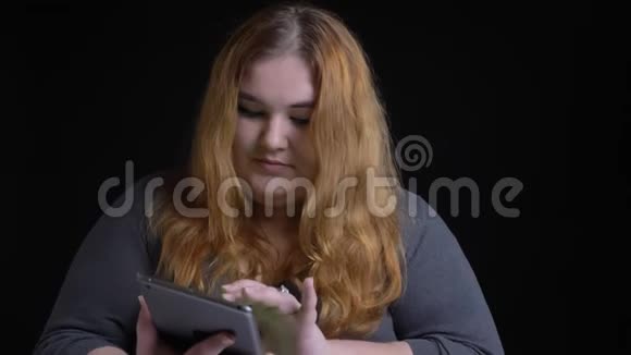 使用平板电脑为年轻的超重白种人女性拍摄特写镜头并在镜头中显示绿色屏幕视频的预览图