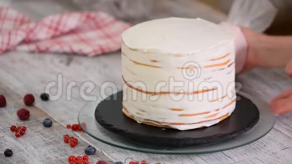 糕点厨师将奶油填充到海绵蛋糕层上视频的预览图