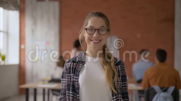 小有趣的学生女孩笑得很开心竖起大拇指观众背景下的学生学生视频的预览图