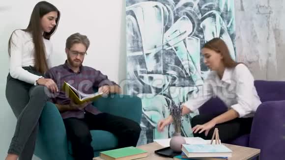 办公室工作人员坐在舒适的扶手椅和学习论文现代办公室创意商业团队会议视频的预览图