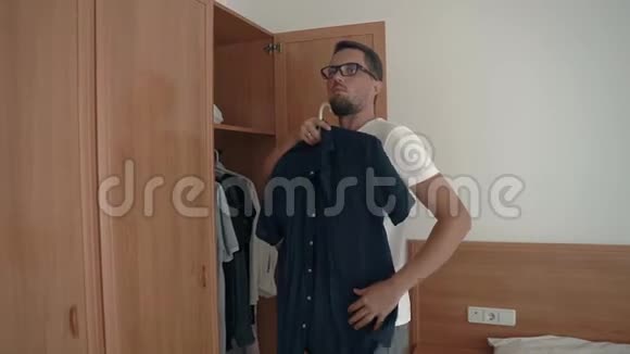 在衣柜里挑选衣服的男人视频的预览图