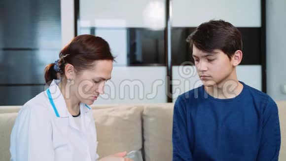 女医生向一个年轻人展示了一种新的更强大的助听器视频的预览图