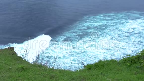 从绿色的山边看海面上有白色泡沫的水波汹涌的海浪青绿色水视频的预览图