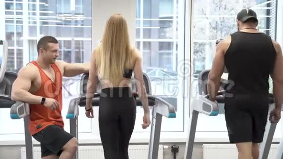 一群在健身房的跑步机上进行有氧运动训练的年轻人视频的预览图