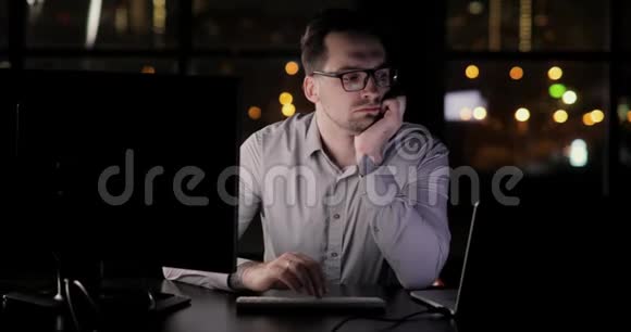 疲惫的程序员在办公室加班深夜在键盘上打字视频的预览图