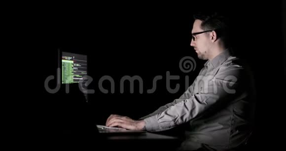 程序员正在办公室加班深夜坐在两台显示器前视频的预览图