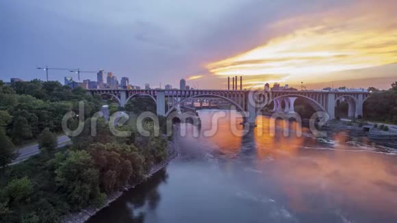 日落时明尼阿波利斯横跨密西西比河的桥梁在市中心天际线前的广角长曝光视频的预览图