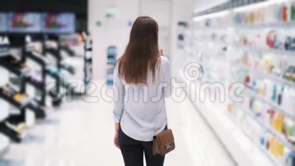从侧面看女人在化妆品店的货架上慢动作视频的预览图