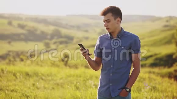 年轻人在户外使用手机有魅力的男人在手机上说话开朗笑而不语视频的预览图