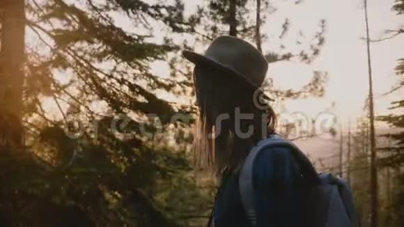侧视特写镜头疲惫的旅游女孩长发漫步在森林道路上日落约塞米蒂公园慢动作视频的预览图
