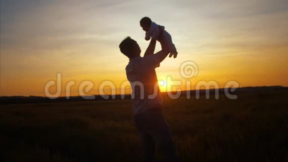 爸爸在金色太阳的日落时把孩子扔了慢动作视频的预览图