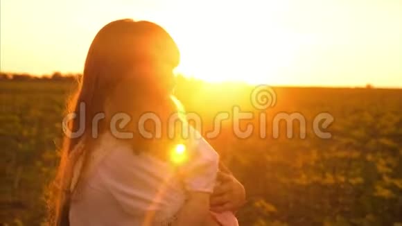 小女孩在夕阳下摇晃着小婴儿剪影母婴在我妈妈怀里睡觉的孩子视频的预览图