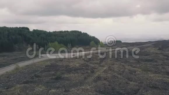 埃特纳山斜坡的鸟瞰图飞行无人机飞过道路和干燥的熔岩意大利西西里视频的预览图