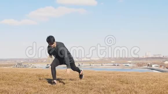 一个穿黑色衣服的人在草地上表演杂技视频的预览图