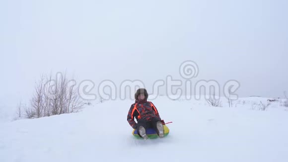 快乐的人骑着雪橇从高高的雪山和微笑冬天人们骑着雪碟圣诞节假期视频的预览图