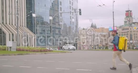 白种人成年送货员带背包过马路的城市户外画像视频的预览图