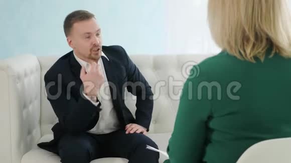 商人坐在沙发上与女心理学家交谈视频的预览图