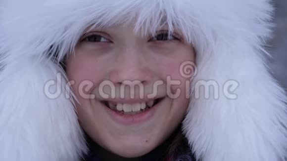 美丽的女孩在冬天下雪的公园里微笑白雪森林里快乐的少年视频的预览图