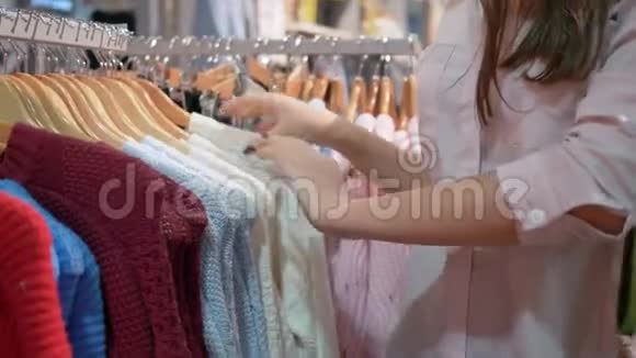 购物者的生活方式顾客们的手在打折时在精品店里挑选时尚的新衣服视频的预览图