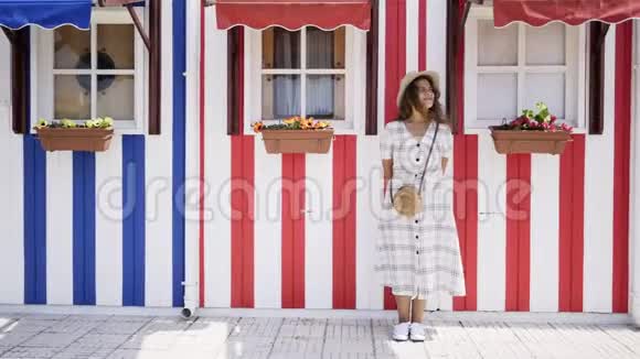 站在背景彩色房子里的女人视频的预览图