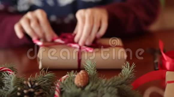在圣诞礼物上人们的双手系着蝴蝶结近距离观看男性用纸包现在的盒子加上杉枝视频的预览图