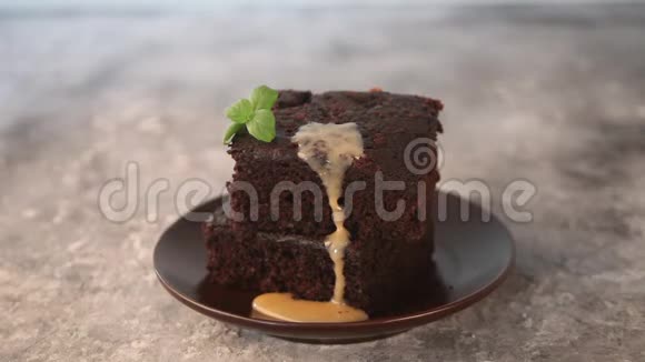 从一块手工制作的巧克力蛋糕上浇上美味的巧克力焦糖糖浆糖霜视频的预览图