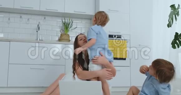 爱的母亲和孩子拥抱玩得开心坐在地板上欢乐幸福的家庭接下来的比赛视频的预览图