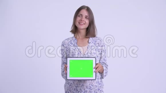 年轻的年轻孕妇一边思考一边展示数码平板电脑视频的预览图