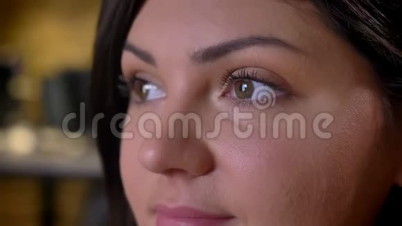 成年白种人女性脸的特写镜头棕色眼睛向前看然后在室内拍摄视频的预览图