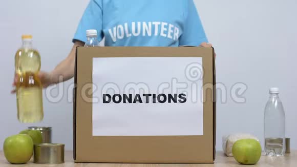 青年志愿者将罐装食品放入捐赠箱中工作社会中心视频的预览图