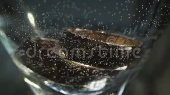 结婚戒指和饮料放在玻璃杯里视频的预览图