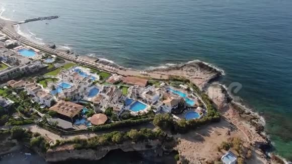 从海岸线上的无人机俯瞰度假胜地和酒店视频的预览图