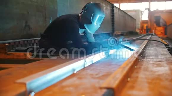 一个戴防护面罩的人在工厂里焊接角落视频的预览图