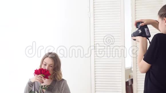 漂亮的女模特在白色背景上捧着红色的花媒体浪漫温柔的摄影与可爱的女人视频的预览图