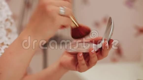 女孩把粉末涂在刷子上化妆的女孩视频的预览图
