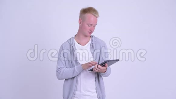 年轻的金发帅哥用数码平板电脑思考问题视频的预览图