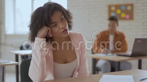 疲倦困倦的女人睡在讲座里皮肤黑的女孩在打哈欠背景中的学生群体4k视频的预览图