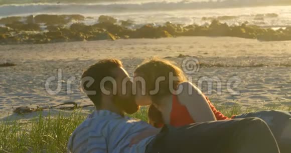 美丽浪漫的情侣躺在沙滩上亲吻视频的预览图