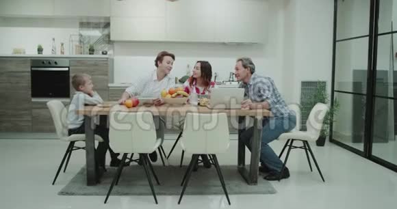 在现代化的厨房里一个成熟的家庭在一起吃饭的时候玩得很开心看着视频的预览图