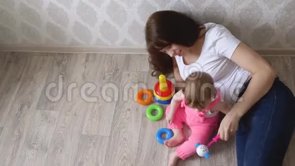 年轻的妈妈在玩具里玩她的小宝宝视频的预览图