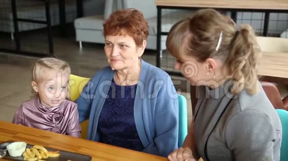 小女孩正在和她的母亲和祖母说话视频的预览图
