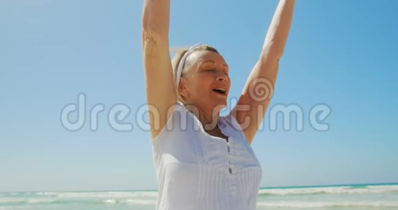 活跃的高加索女性在海滩上做瑜伽的正面景色视频的预览图