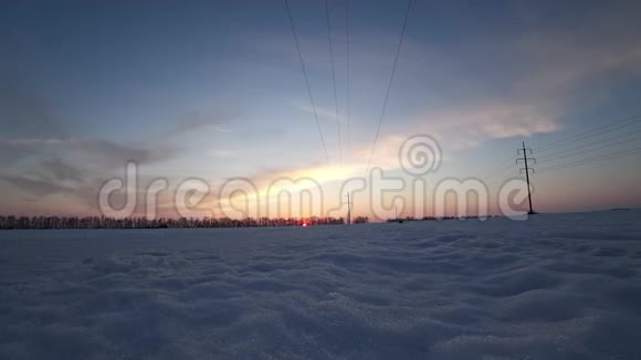 日落时分在寒冷晴朗的冬日有飞机和电源线的景观视频的预览图