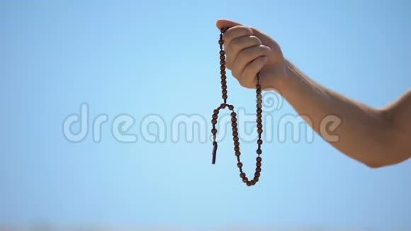 手拿念珠在蓝色背景上向上帝祈祷宗教灵性视频的预览图