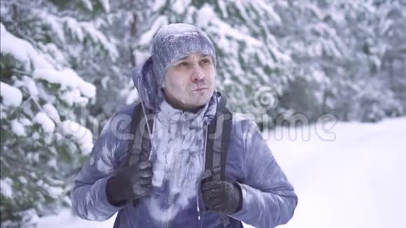 冰雪中的冻人背着背包在树林中行走视频的预览图