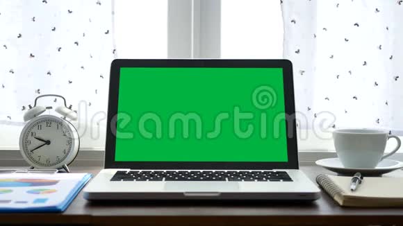4K笔记本电脑带有绿色屏幕色键放在靠近窗户的办公桌上并有白色窗帘吹过视频的预览图