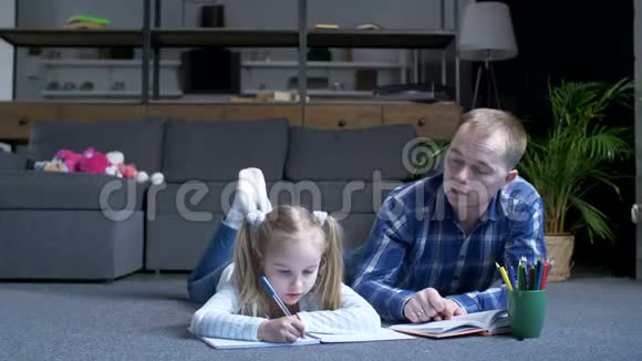 照顾孩子的父亲和在家学习的学龄前女孩视频的预览图