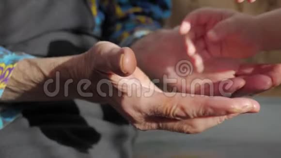 孩子的手和年长女人的手一个孩子正在拥抱祖母手视频的预览图