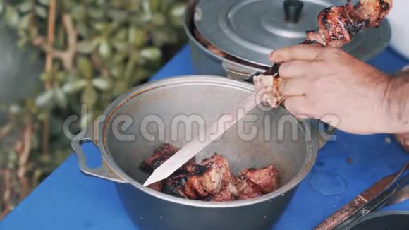 把人的双手紧紧地从肉串上拿下来用刀切到菜慢动作视频的预览图